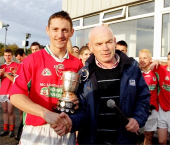Carn captain Paddy Nelson receives the Junior Championship Cup from Donegal GAA chariman Sean Kelly.