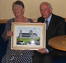 Bridie and John with their painting of the Sacred Heart Church in Carndonagh