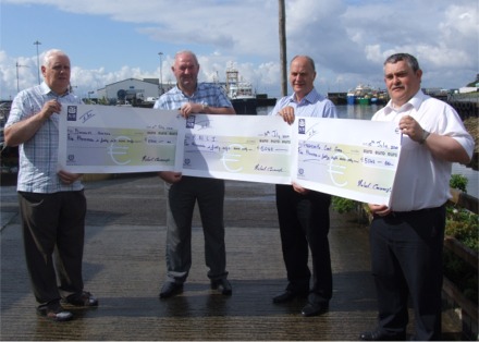 Well known Donegal fisherman Michael Cavanagh, second from right, presents cheques for 5,048 euro to, from left, Andy Boyle of the Donegal Hospice, John McClenaghan of the RNLI and Charles Cavanagh of Greencastle Coast Guard.