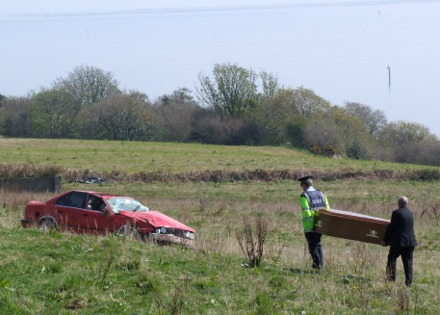 A Garda and undertaker carry a coffin across the field to the scene of Sunday's fatal accident at Clar, Redcastle.