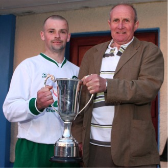 Clonmany captain Raymond McDaid receives the Willie Grant West End League Cup trophy from Lawrence McColgan, League chairman.