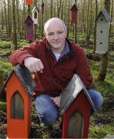 Shane with a selection of his custom-made bird houses.