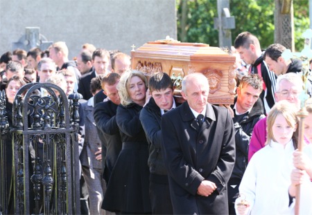 PJ McLaughlin's remains are carried from the church by family members.
