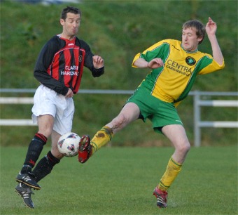 Inishowen's Dermot Diver in green and yellow, gets a foot to his 50/50 with Donegal's Paddy McDaid. Photo: Evan Logan.