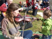 Kathleen OHara Farren plays a tune on the fiddle with the help of little Odhran Lafferty from Ballybrack.