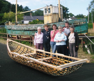 Members of Inishowen cancer Group Éist and boat builder Dónal MacPolin, with the skeleton of their currach before it was finished.