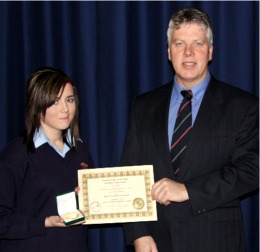 Tanya Mulhern being presented with her All-Ireland medal and certificate by her teacher, Mr. Ambrose McCreanor.