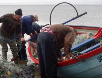 Pat McDonald, gets some help gathering his drift net for the last time. Photo courtesy BBC.